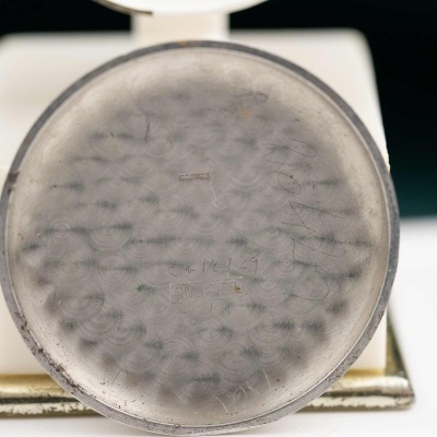 Base metálica circular com padrão de círculos pequenos e textura riscada