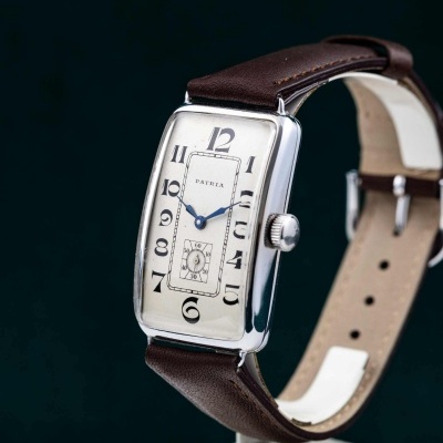 Relógio de pulso com caixa retangular e pulseira castanha de couro