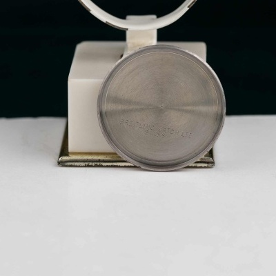 Dispositivo branco e cinza com lente redonda frontal sobre superfície branca