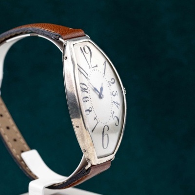 Relógio de pulso com bracelete em pele castanha e mostrador branco com números grandes