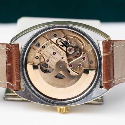 Relógio de pulso com mecanismo interno visível e pulseira de couro castanho