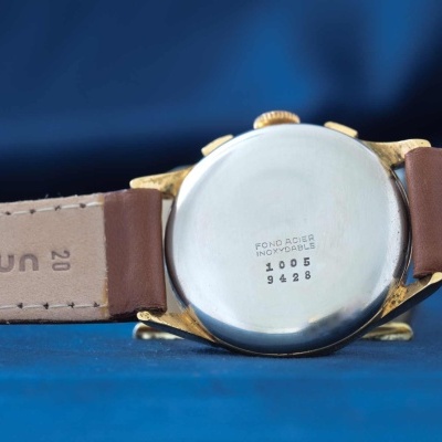 Relógio de pulso com caixa metálica prateada e pulseira castanha de couro