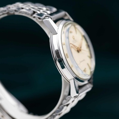 Relógio de pulso com bracelete metálica prateada e mostrador creme