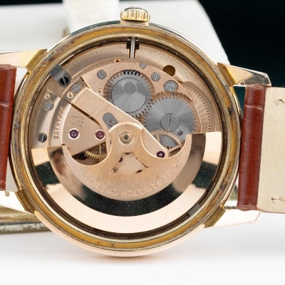 Relógio de pulso mecânico com mecanismo visível e bracelete castanha