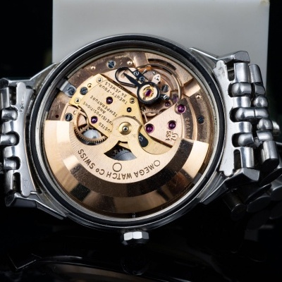 Relógio Omega com mecanismo interno visível e bracelete metálica de aço inoxidável