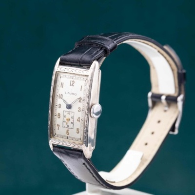 Relógio de pulso com caixa retangular, mostrador branco e bracelete de couro preto