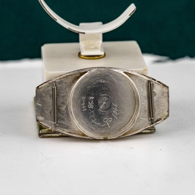 parte traseira de relógio de pulso de metal prateado com texto gravado