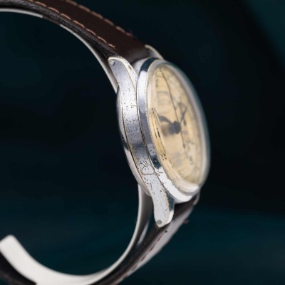 Relógio de pulso com caixa metálica prateada e bracelete castanha de couro