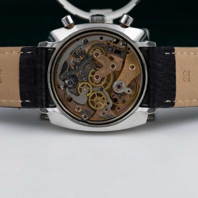 Relógio mecânico com caixa metálica prateada e pulseira de couro castanho