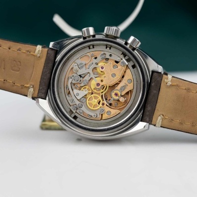 Relógio de pulso com mecanismo interno visível e pulseira de couro bege.