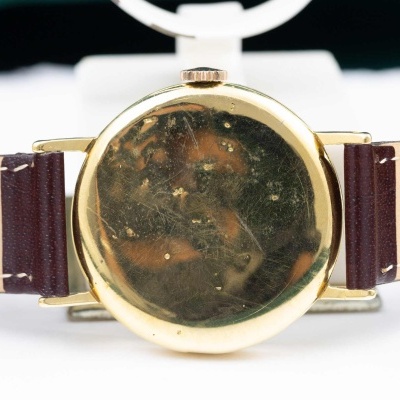 Relógio de pulso dourado com bracelete de couro bege e castanho escuro