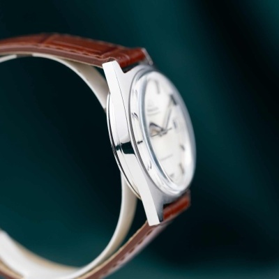 Relógio com caixa metálica prateada e bracelete castanha