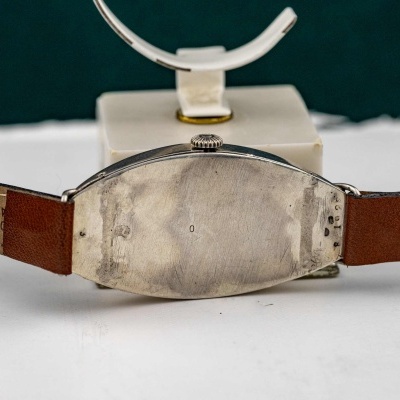 Relógio com verso metálico oval e correia castanha de couro