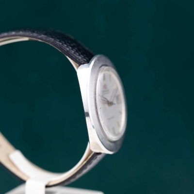 Relógio de pulso metálico prateado com bracelete preta texturizada