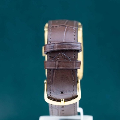 Relógio com bracelete de couro castanho e fivela dourada