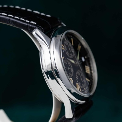 Relógio metálico prateado com mostrador preto e bracelete de couro preto