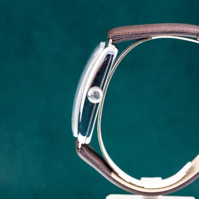 Relógio de pulso com caixa metálica prateada e bracelete castanha em pele