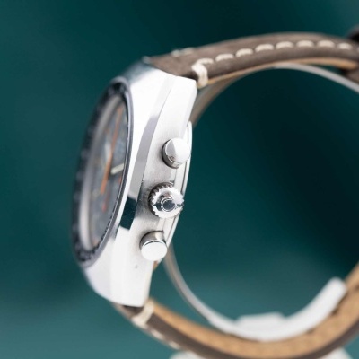 Relógio metálico com bracelete de pele castanha e detalhes prateados