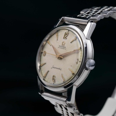 Relógio de pulso Omega Seamaster com mostrador creme e bracelete metálico.