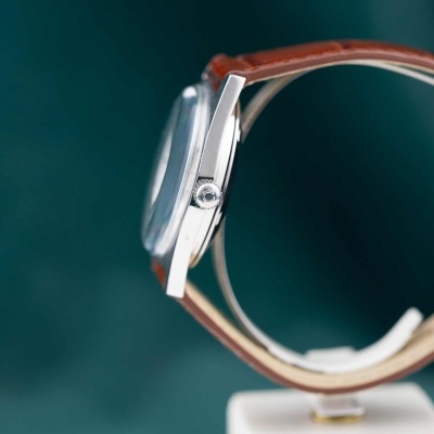 Relógio de pulso com caixa metálica prateada e pulseira de couro castanha