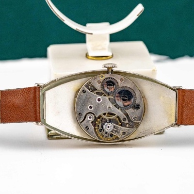 Relógio com bracelete de pele castanha e mecanismo interno visível