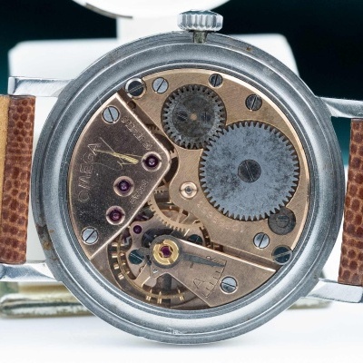 Relógio com mecanismo interno visível e bracelete de couro castanho