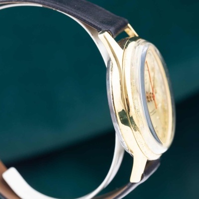 Relógio de pulso dourado com pulseira de couro castanha