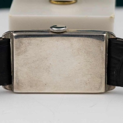 Relógio retangular com caixa metálica prateada e bracelete de couro preto