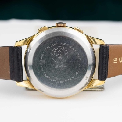 Relógio de pulso com caixa dourada e pulseira castanha com texto sofylon