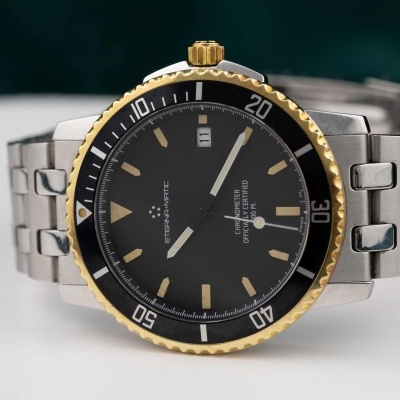 Relógio de pulso em aço inox com mostrador preto e bisel dourado