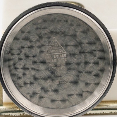 Interior da tampa de relógio OMEGA em aço inoxidável com inscrições e número de série.