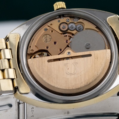 Relógio com mecanismo interno exposto e bracelete dourada