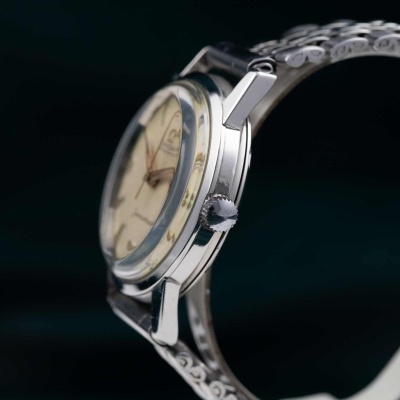 Relógio de pulso com caixa e bracelete metálicos detalhados e mostrador bege