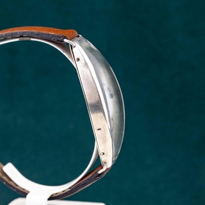 Relógio de pulso com caixa metálica prateada e bracelete em couro castanho