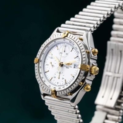 Relógio Breitling prata com detalhes dourados e mostrador branco