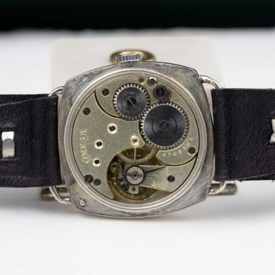 Relógio de pulso aberto com mecanismo interno visível e pulseira preta