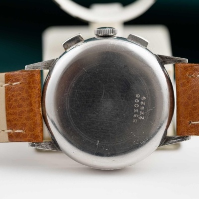 Relógio de pulso com caixa metálica e bracelete de pele castanha.