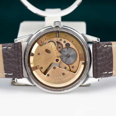 Relógio com fundo transparente mostrando mecanismo interno e correia de pele castanha