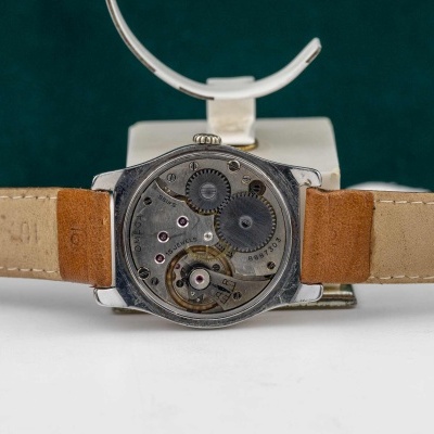 Relógio de pulso com interior mecânico visível e pulseira em pele castanha