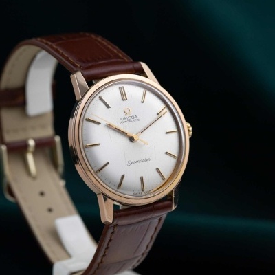 Relógio Omega Seamaster com caixa dourada e bracelete em pele castanha