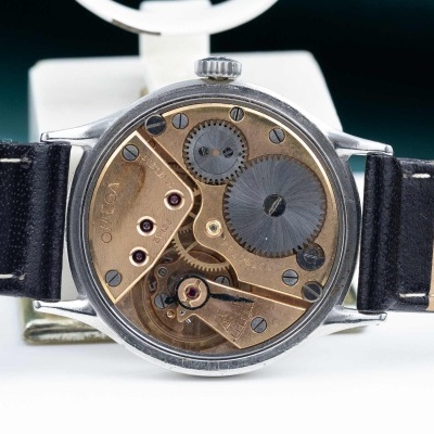 Relógio de pulso com mecanismo interno visível e bracelete preta.