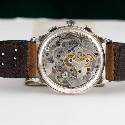 Relógio com bracelete em pele e fundo transparente mostrando mecanismo