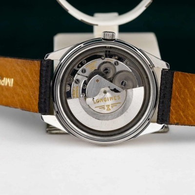 Relógio com bracelete de pele castanha e mecanismo interno visível