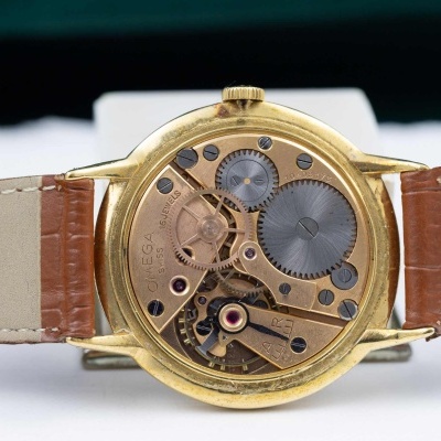 Relógio com interior mecânico visível e pulseira castanha em couro