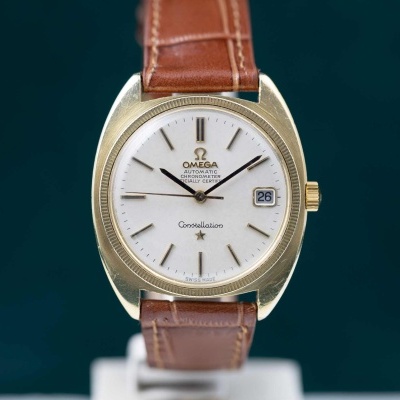 Relógio Omega Constellation dourado com mostrador branco e bracelete castanha em pele