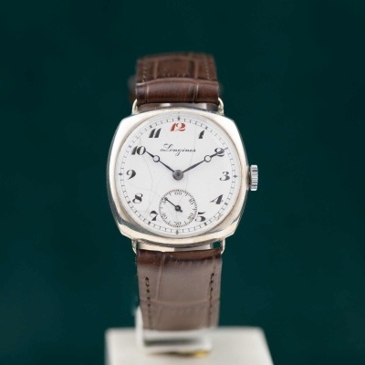 Relógio de pulso Longines com mostrador branco e correia castanha em fundo verde-azulado