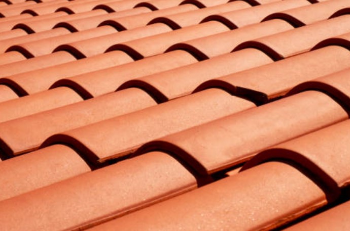 Telhado com telhas de cerâmica vermelha em camadas onduladas.