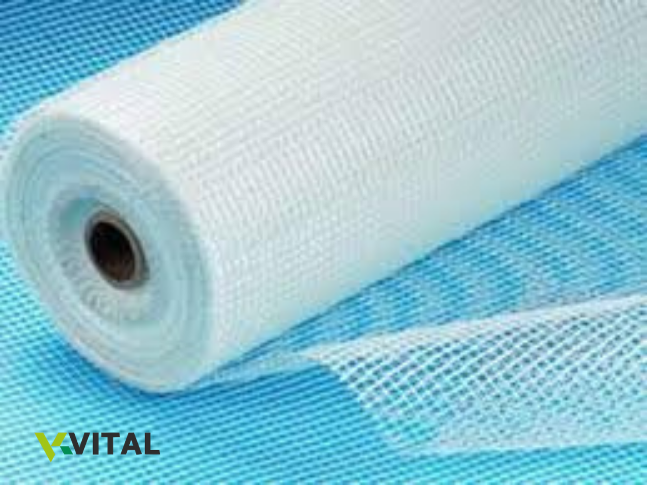 Rolo de tela branca de malha quadrada sobre superfície azul com logótipo 'VITAL'