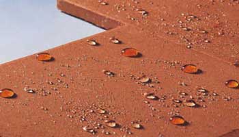 Superfície castanho-claro com gotas de água visíveis