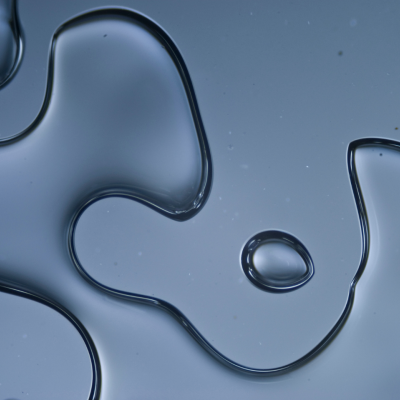 Gotas de líquido transparente em superfície lisa azulada